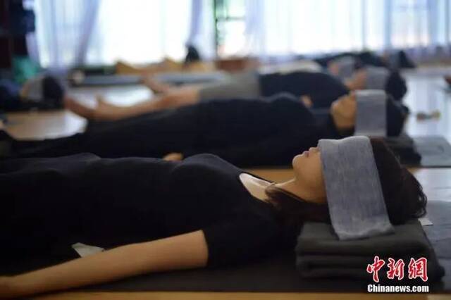 资料图：广州一家瑜伽馆开了一门“睡眠术”课。图为学生在老师指导下安然入睡。中新社记者姬东摄
