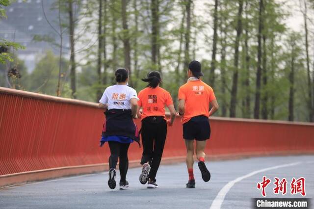 张志宏(右一)正在陪跑一位视障人士。王磊摄